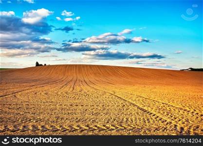 Agricultural landscape, arable crop field after mechanized planting. Linear plowed agriculture on hills. Minsk region, Belarus
