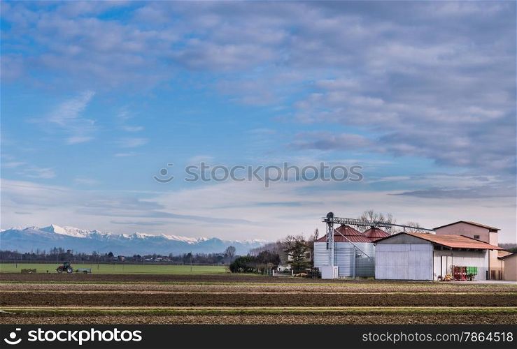 Agricultural landscape with farm, and in the background the Italian Alps