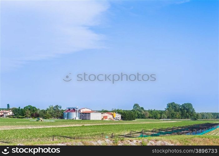 Agricultural landscape with farm silos and tractor