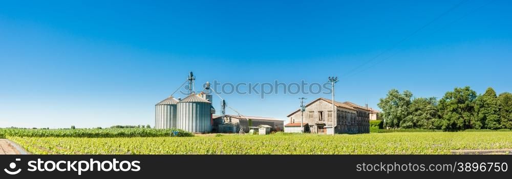 Agricultural landscape with old farm and silos