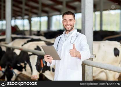 agriculture industry, farming, people and animal husbandry concept - veterinarian or doctor with tablet pc computer and herd of cows in cowshed on dairy farm showing thumbs up hand sign