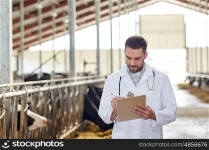 agriculture industry, farming, people and animal husbandry concept - veterinarian or doctor with clipboard and herd of cows in cowshed on dairy farm
