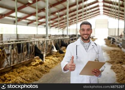 agriculture industry, farming, people and animal husbandry concept - veterinarian or doctor with clipboard and herd of cows in cowshed on dairy farm showing thumbs up hand sign