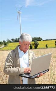 Agronomist in wheat field with laptop computer