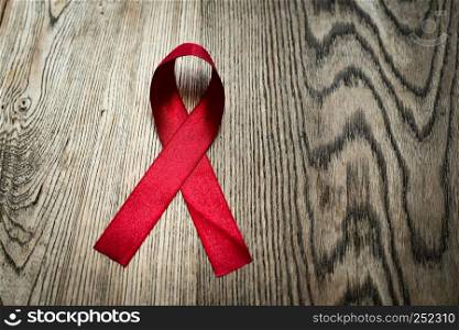 Aids Awareness Sign Red Ribbon, the fight against AIDS sign on wooden table