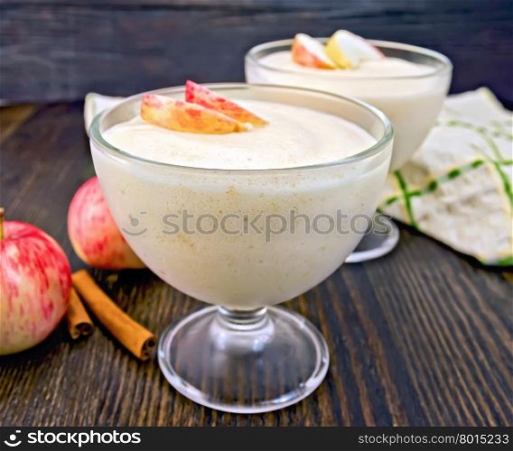 Air apple jelly in a glass bowl, red apples and cinnamon, towel on a background of wooden boards