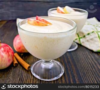Air apple jelly in a glass bowl, red apples and cinnamon, towel on a background of wooden boards