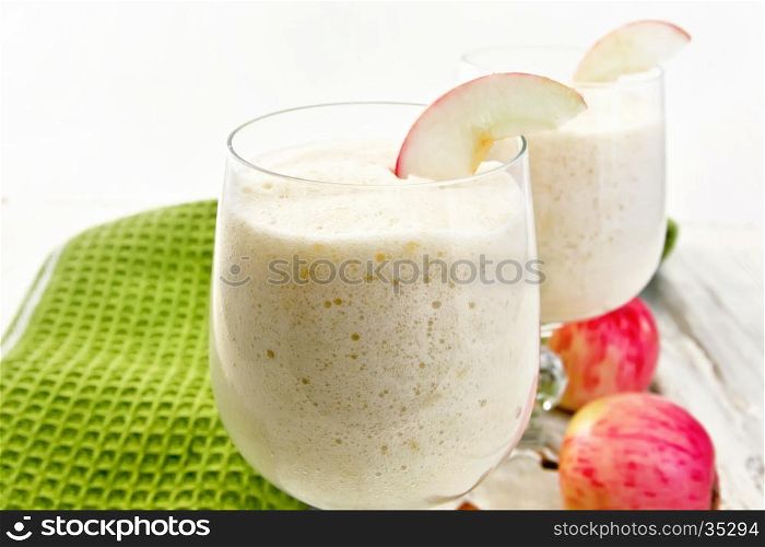 Air apple jelly in glass glasses, red apples and a napkin on a wooden boards background