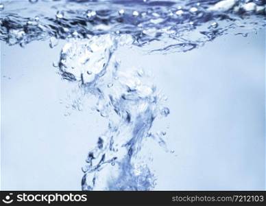 Air bubbles rising up to surface in blue pure water. Abstract background.