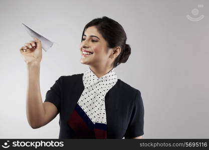 Air hostess holding a paper plane