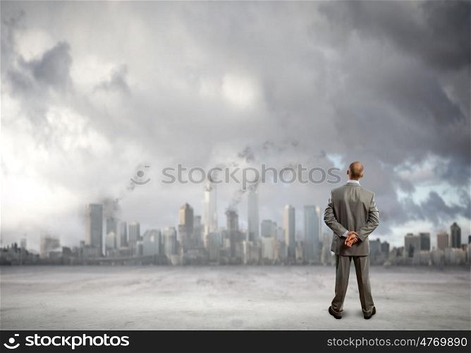 Air pollution. rear view of businessman looking at scene of polluted city