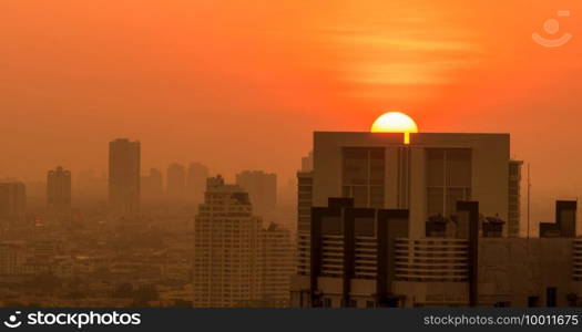 Air pollution. Smog and fine dust of pm2.5 covered city in the morning with orange sunrise sky. Cityscape with polluted air. Dirty environment. Urban toxic dust. Unhealthy air. Urban unhealthy living.