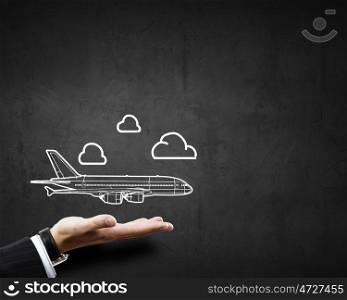 Air transportation. Close up of businessman hand holding airplane sign