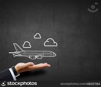 Air transportation. Close up of businessman hand holding airplane sign