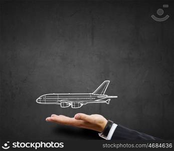 Air transportation. Close up of businessman hand holding drawn airplane
