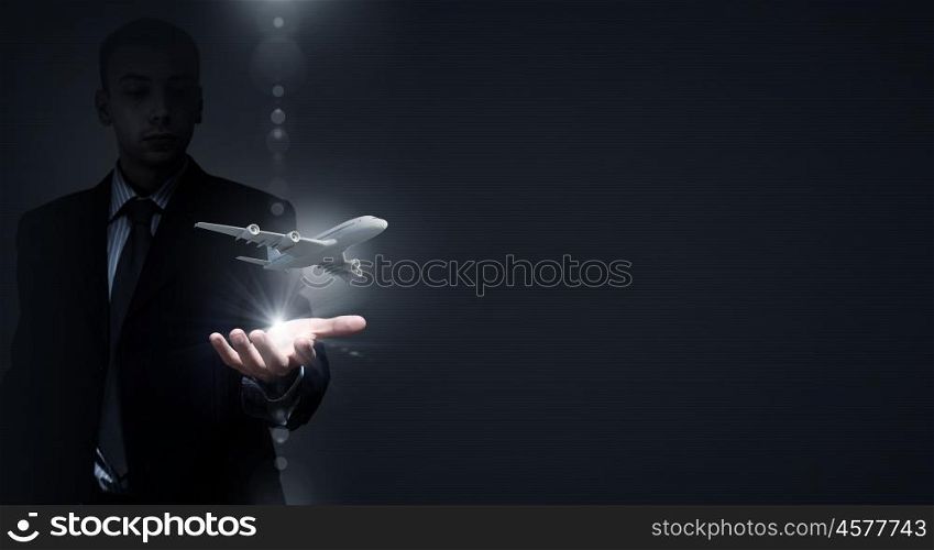 Air transportation. Close up of businessman hands holding airplane sign