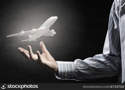 Air transportation concept. Close up of male hand holding airplane model