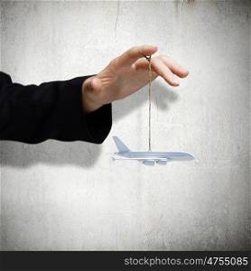 Aircraft concept. Close up of male hand holding airplane model on rope