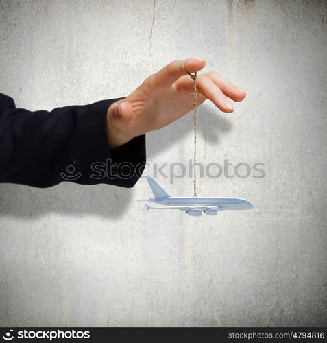 Aircraft concept. Close up of male hand holding airplane model on rope