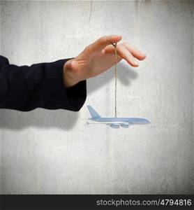 Aircraft concept. Close up of male hand holding airplane model on rope