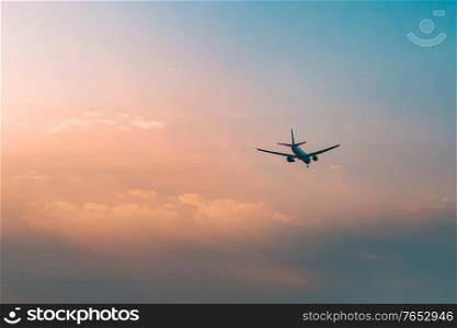 Aircraft flying over clouds, aviation sunset background, essential transport for business and travel