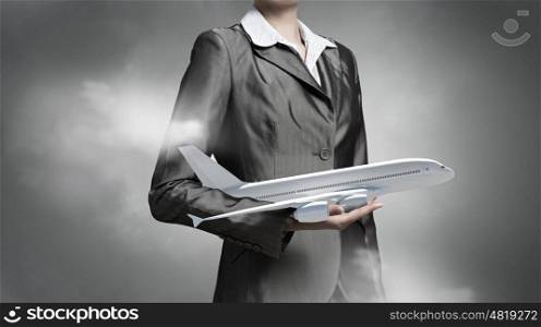 Aircraft or business travel concept. Close view of businesswoman holding in hands airplane model
