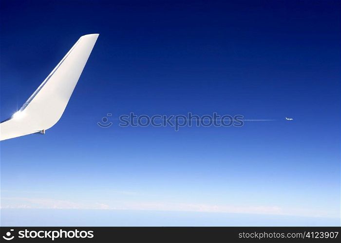 Aircraft wing detail flying high up in deep blue sky
