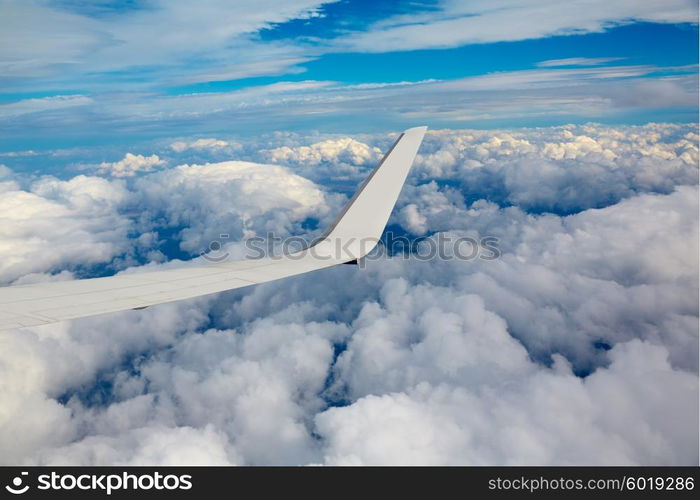 Aircraft wing in a cloudy stormy clouds sky flying