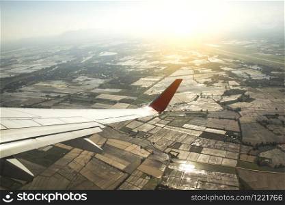 Aircraft wing on the clouds with top view Agricultural field , flying traveling background