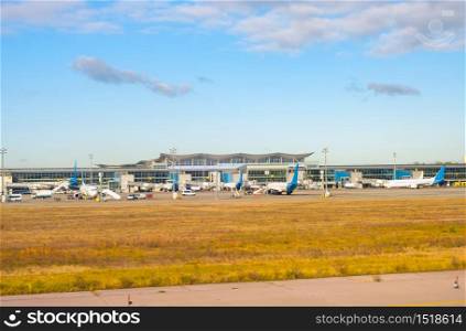 Airfield in sunshine, airplanes by the terminal modern building, Boryspil International Airport, Kyiv, Ukraine