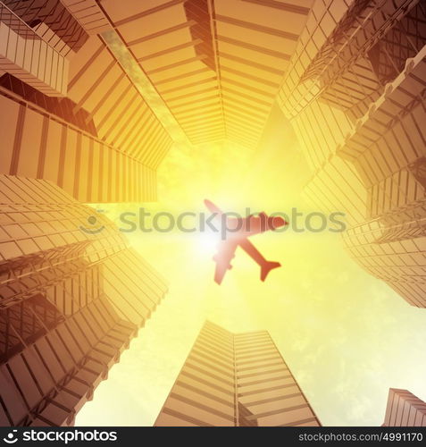 Airplane above city. Image of airplane flying above skyscrapers. Bottom view