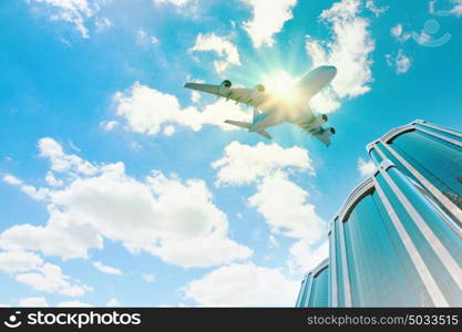 Airplane above city. Image of airplane flying above skyscrapers. Bottom view