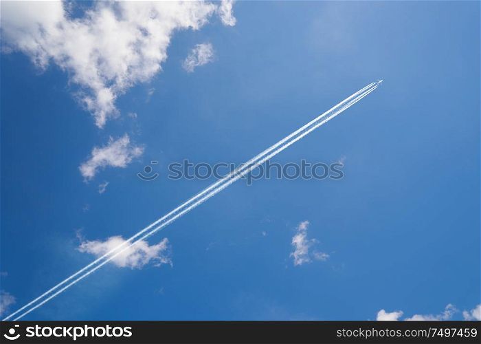 Airplane contrail against skyblue sky with white cloud .
