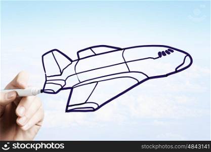 Airplane design. Person drawing airplane model on sky background