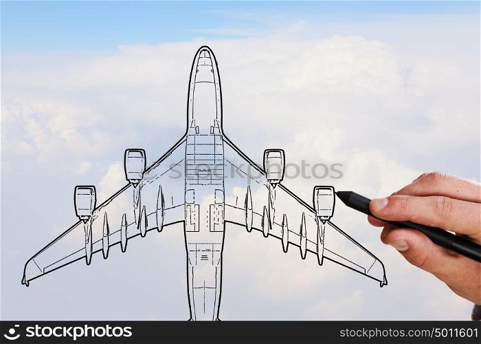 Airplane design. Person drawing airplane model on sky background