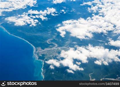 Airplane fly above the land and ocean