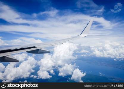 Airplane flying in a blue sunny sky above clouds. Airplane flying above clouds