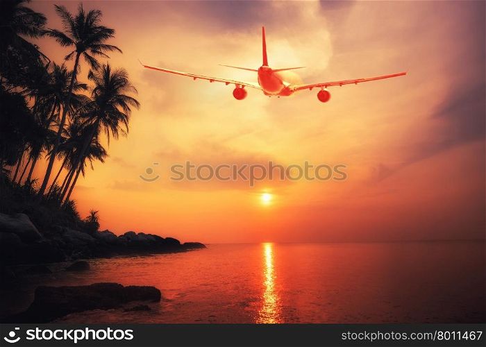 Airplane flying over amazing tropical sunset landscape. Thailand travel destinations