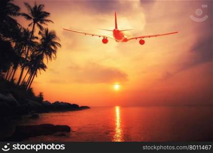 Airplane flying over amazing tropical sunset landscape. Thailand travel destinations