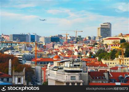 Airplane flying over Lisbon Downtown at sunset. Portugal