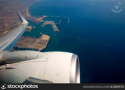 Airplane flying over Valencia port in Spain and Mediterranean Sea