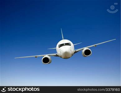 Airplane in flight against a bright blue sky