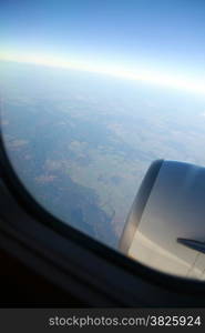 Airplane in the blue sky engine and wings white clouds