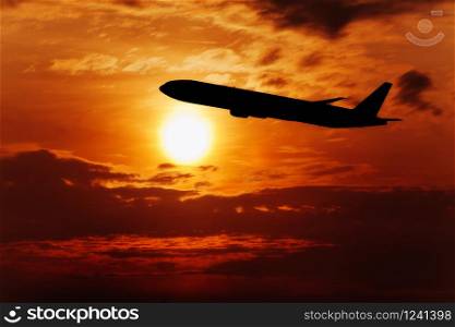 Airplane In The Sky At Sunset. Travel background with passenger plane.. Big Sun on sunset. Nature composition. Orange sunset.