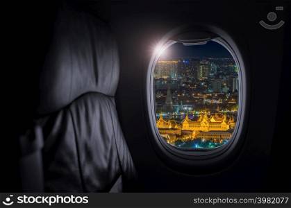 Airplane interior with window view of Grand Palace is actually a collection of structures in Rattanakosin, the historic center of Bangkok, Thailand, Concept of travel and air transportation.. Travel and transportation concept