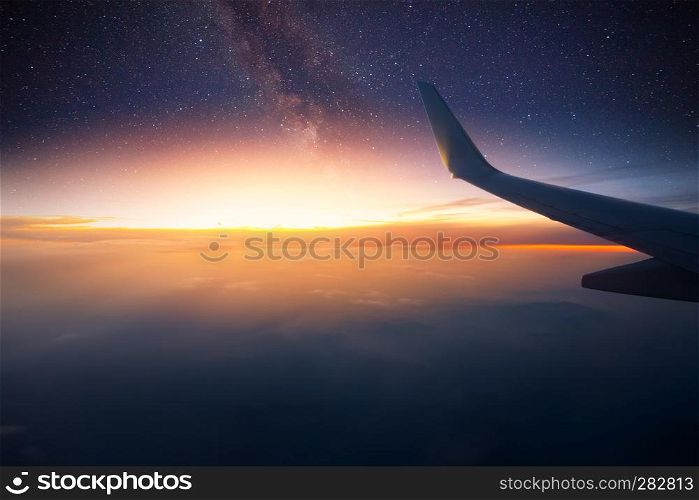 Airplane is flying at night. Space Milky Way view from plane window. Dark clear starry sky