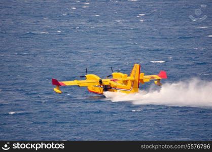 Airplane on sea taking water to drop over fire