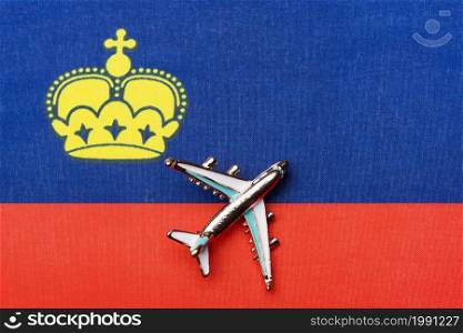 Airplane over the flag of Liechtenstein the concept of the journey. Toy plane, tourism and travel.. Airplane over the flag of Liechtenstein the concept of the journey.