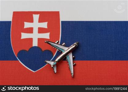 Airplane over the flag of Slovakia, the concept of travel. Toy airplane on the flag as a background.. Airplane over the flag of Slovakia, the concept of travel.