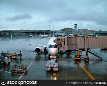 Airplane passenger jet loading at airport.